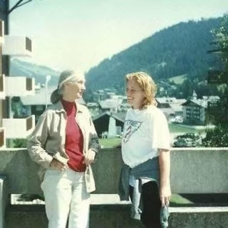 Picture of author with Dr. Goodall looking at one another with Swiss Alps in background.